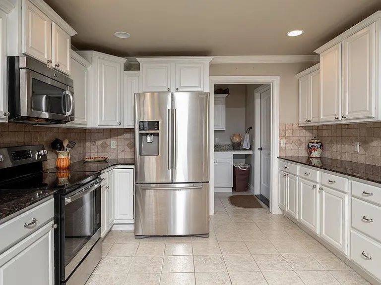 Kitchen with stainless steel appliances and tile floors and a super quiet dishwasher.