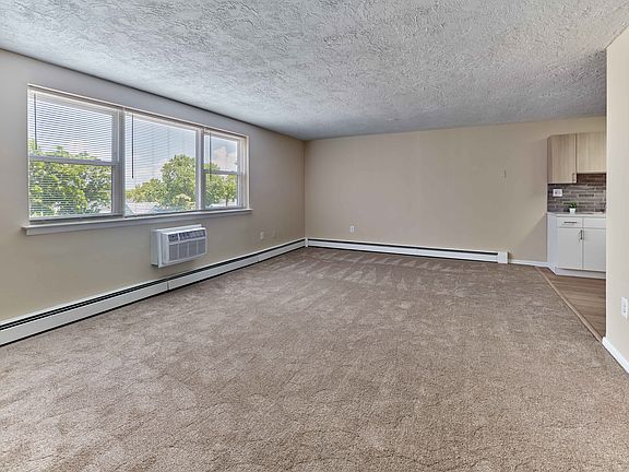 Spacious living area with natural light at Audubon Arms Apartments