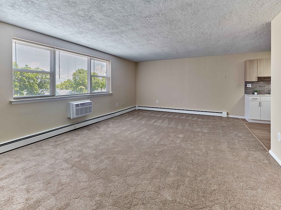 Spacious living area with natural light at Audubon Arms Apartments