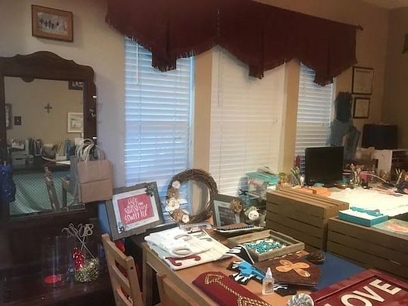 Triple windows grace the elegant front dining room - here used as a cheerful workroom for the crafter.