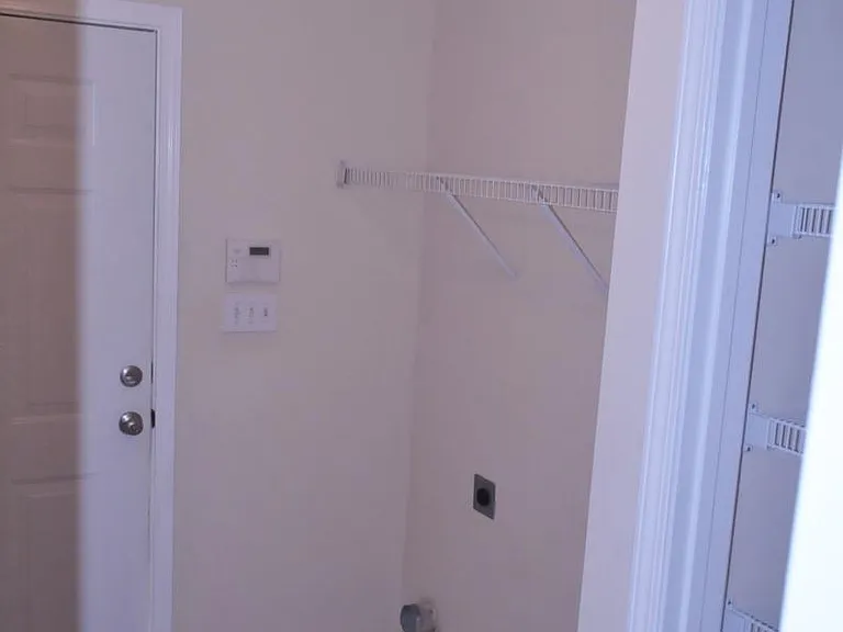 laundry room with hooks, with entrance to the garage