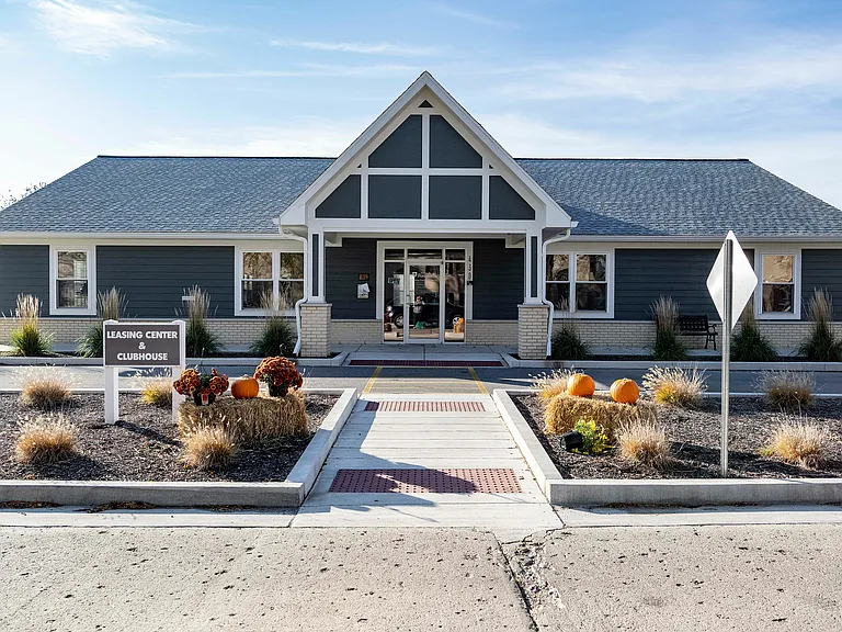 Inviting leasing center and clubhouse with charming autumn decorations and modern architecture.