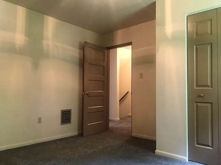 Third bedroom with a view of stairs leading to first floor level.