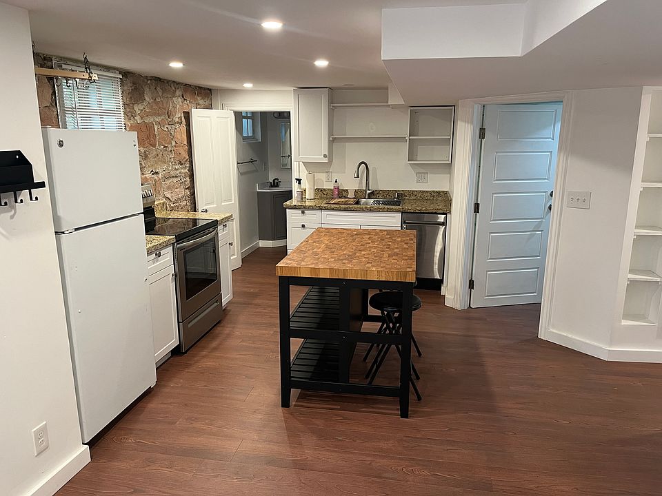Kitchen. Door left of the island is to the bathroom, door right of the island is to the laundry room, and hallway to the far right goes to the bedrooms