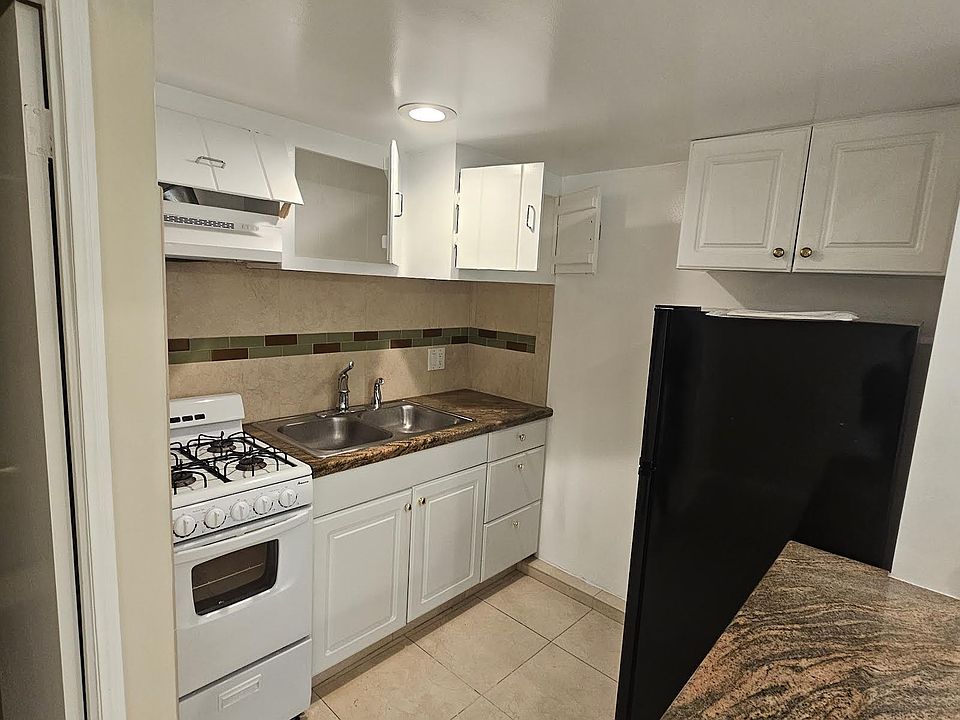 kitchen area with range and refrigerator granite counter top and bar.