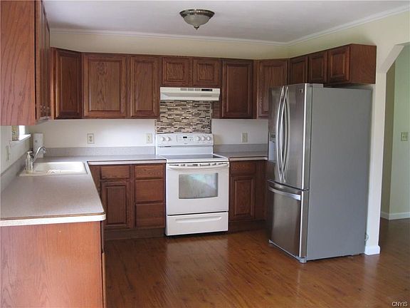 Clean and Spacious Kitchen with New Refrigerator.  Smooth top stove with modern back splash and dishwasher.