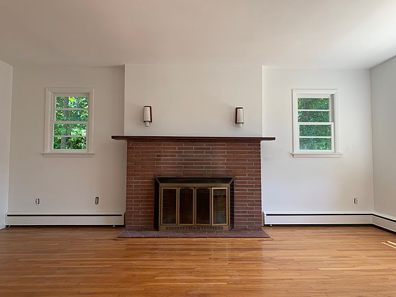 Living room with fireplace mantle and vintage sconces.