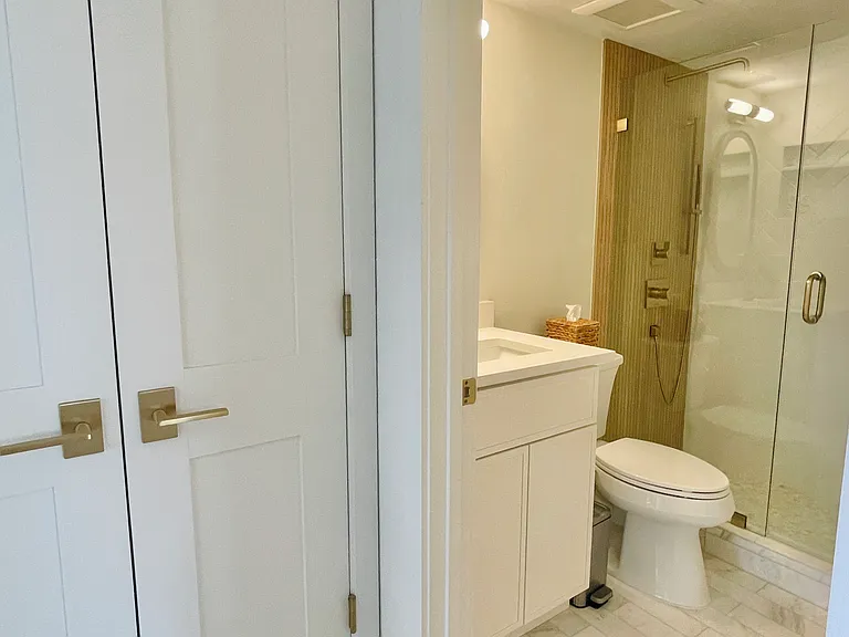 Guest bathroom w/marble tiles and LED mirror