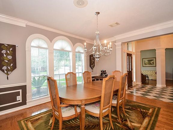 Arched windows, wood flooring and new chandelier in the dining room.