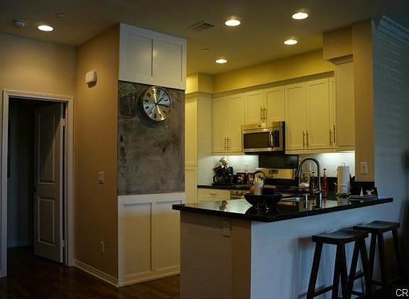 Full white subway tile backsplash, granite counters and stainless steel appliances.