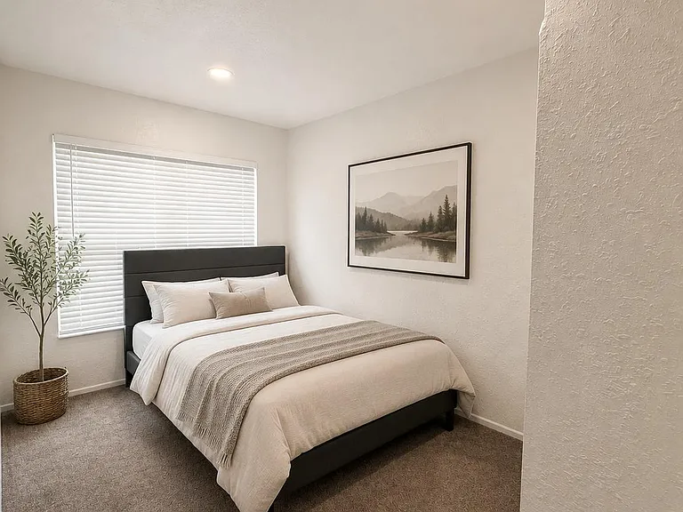 Carpeted bedroom with a queen bed, window with blinds, and overhead recessed lighting for comfortable everyday living.