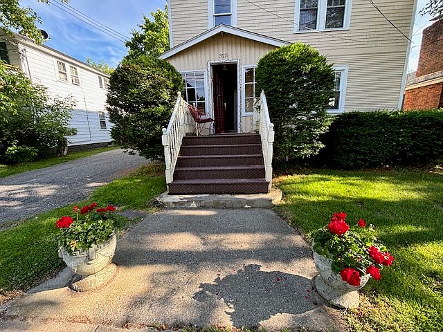 Entry way from street and view of front of house