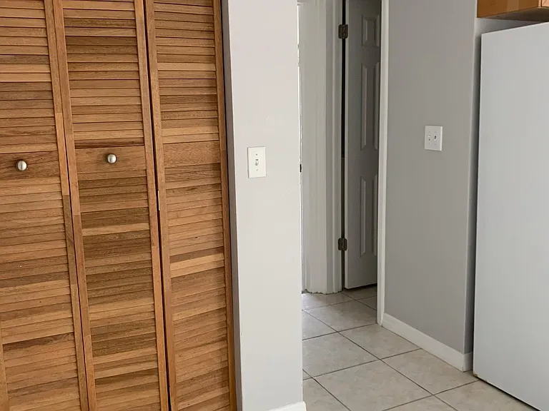Pantry and Hallway with Half Bathroom Leading to Garage