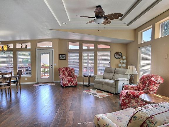 Talk about a wall of windows! This truly keeps the home light and bright.  There are also faux wood blinds on the windows, and also on the glass front door, for privacy when you want it.>