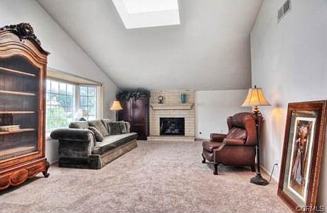 Enjoy a formal living room a skylight, a brick fireplace with ma