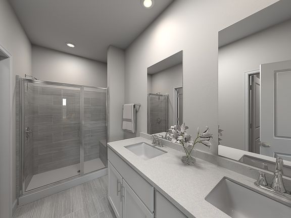 The primary bathroom boasts a dual-sink vanity and spacious walk-in shower.
