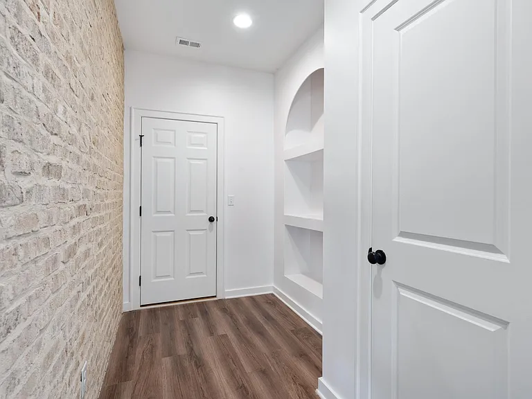garage entryway with mud room shelving and coat closet