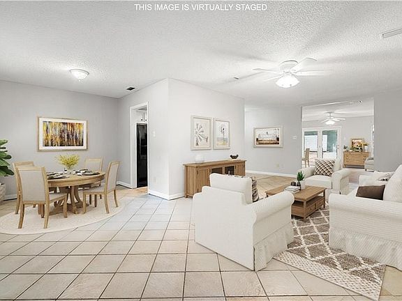 Living area with baseboards, visible vents, a textured ceiling, a ceiling fan, and light tile patterned flooring