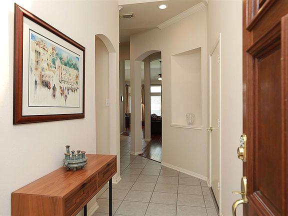 Entryway has arched doorways and art niches. Neutral paint throughout.