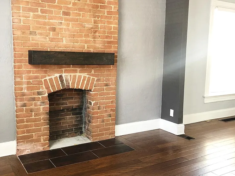 The living room features a beautiful brick fireplace.
