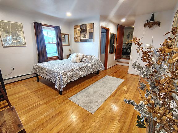 Bedroom on the first floor, with walk in closet, 3 big windows & a full size bathroom, equipped for the elderly who may not be able to climb many stairs. This is a queen size bed & frame.