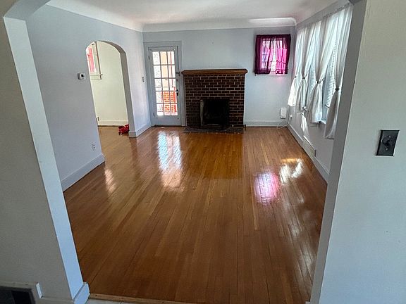 Living Room with Fireplace. French Door to Screened Porch. Just done hardwood floors.