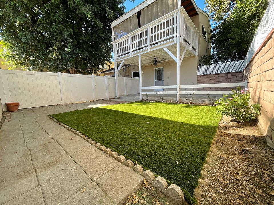 This unit has a spacious private back yard with covered patio, artificial grass, and brick pavers.