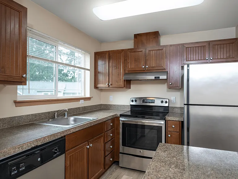 Enjoy cooking in this stylish kitchen featuring stainless steel appliances, sleek countertops, and rich wood cabinetry. Bright and inviting with plenty of storage space! Enjoy cooking in this stylish kitchen featuring stainless steel appliances, sleek cou