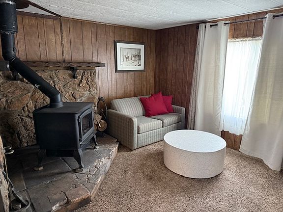 Cozy living area, just off of the dining room with a wood burning stove to keep the place warm and cozy! Currently, this room is furnished.