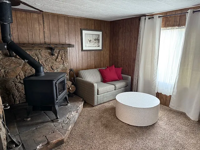 Cozy living area, just off of the dining room with a wood burning stove to keep the place warm and cozy! Currently, this room is furnished.