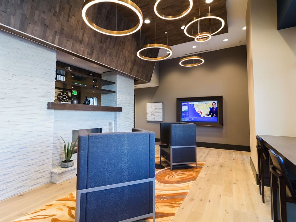 Cozy, modern resident lounge with stunning lighting, a fireplace, lounge seating, at TV and work space