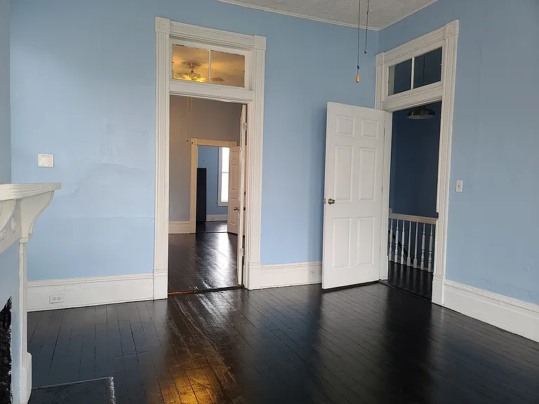 Sunny front room - can be living room or bedroom. Has a closet & decorative fireplace.