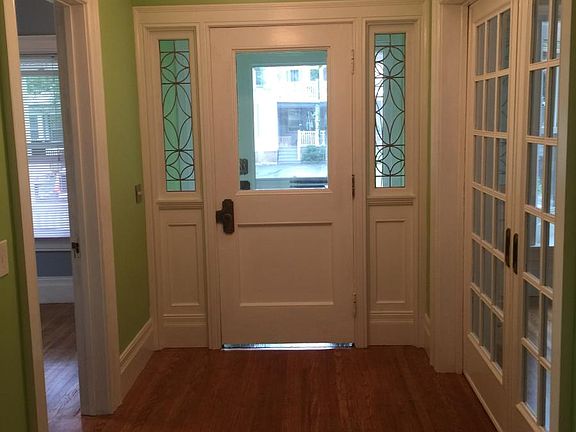 Main hall, smaller front bedroom on left, living room pocket doors on right.