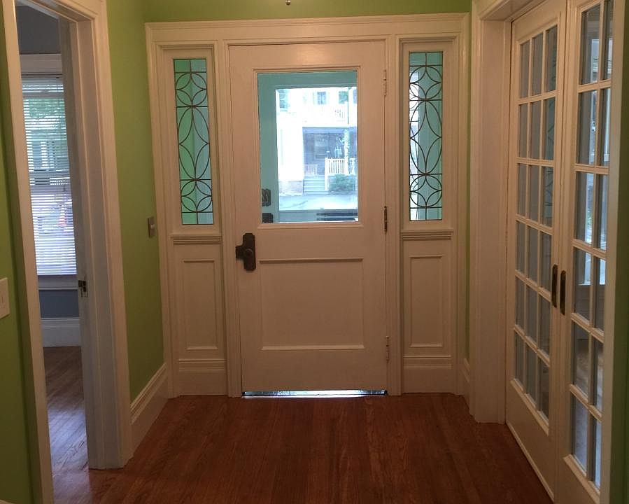 Main hall, smaller front bedroom on left, living room pocket doors on right.