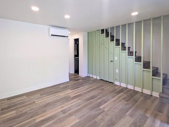 Living Room with Extra Storage Under Vintage Stairs and the Comfort of Brand New Mini Split Heating and Air