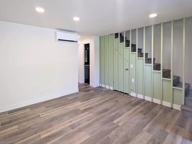 Living Room with Extra Storage Under Vintage Stairs and the Comfort of Brand New Mini Split Heating and Air