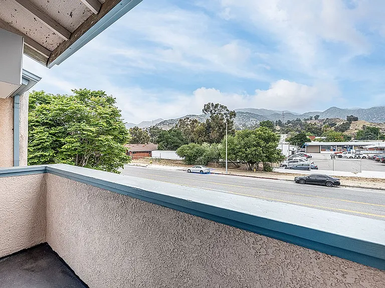 Private balcony with view of tree-lined surrounding community.