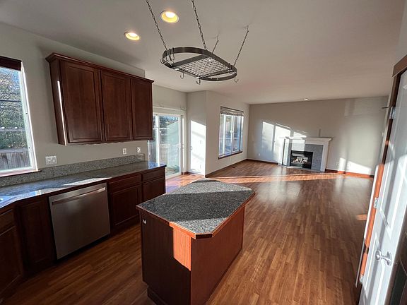 Kitchen view of island, hanging pot rack and dishwasher
