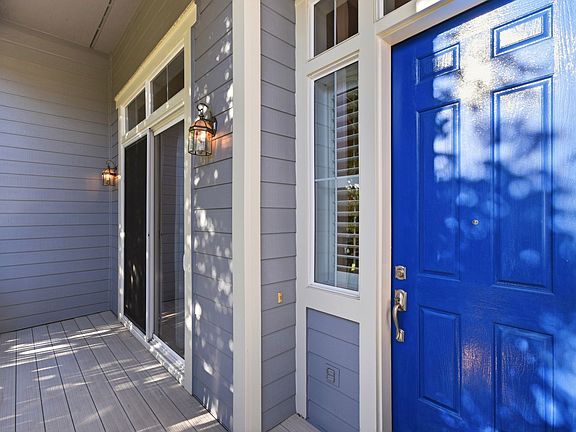 Covered front entry with distinctive blue front door.