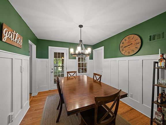 Fully renovated dining room with white wainscoting.