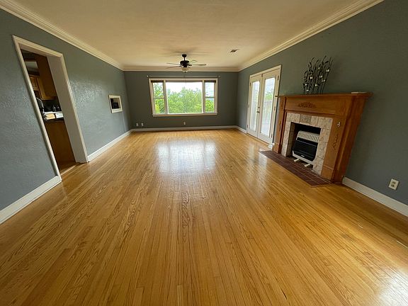 Living room with bay window. Porch door to the right, kitchen door to the left.