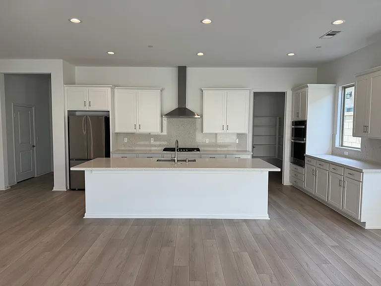 Clean and spotless white kitchen with farmhouse stainless steel sink