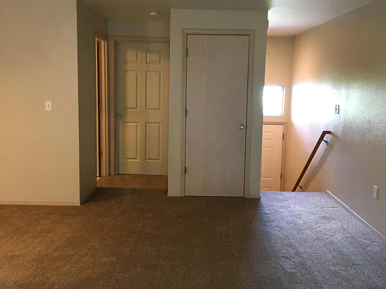 View from living room toward bathroom, master bedroom, hall closet and stairs to front door