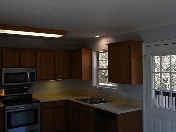 Kitchen overlooking deck and wooded lot.