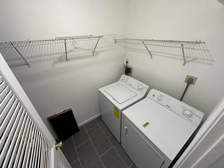 Freshly painted utility closet with washing machine and dryer