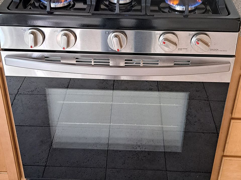 NATURAL GAS RANGE AND OVEN WITH GAS BROILER IN CENTER.