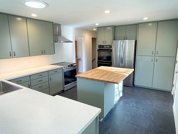 Bright remodeled kitching includes new stainless steel appliances and tons of cabinet storage