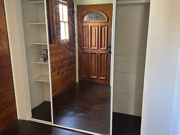 Spacious closet, with shelves on one side and hanging rod on the other side.