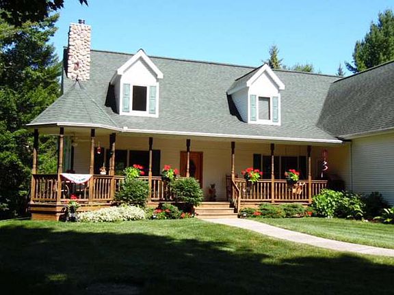 Beautiful plants and flowers border the front covered porch.