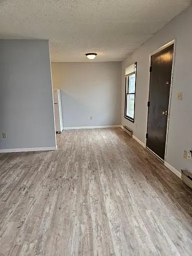 Looking from living room to dining area, entry door.